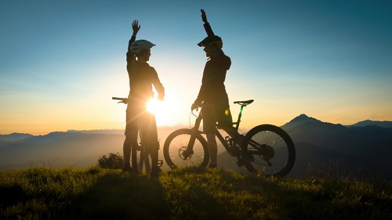 Mountain bikers celebrating at sunset